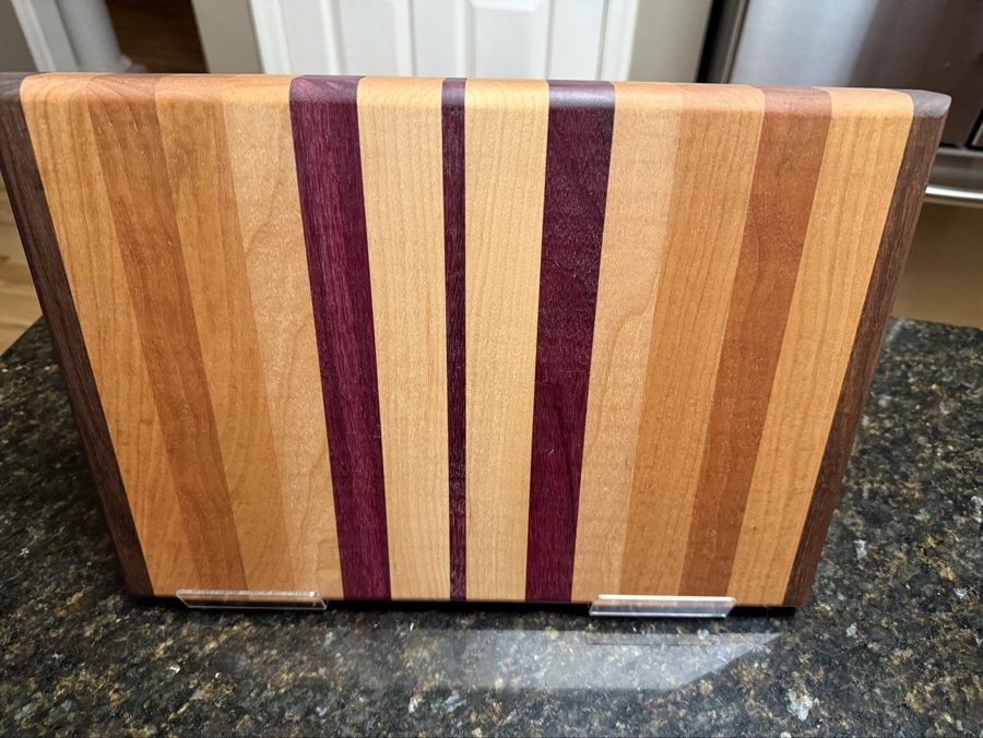 Finished hardwood cutting board, striped grain